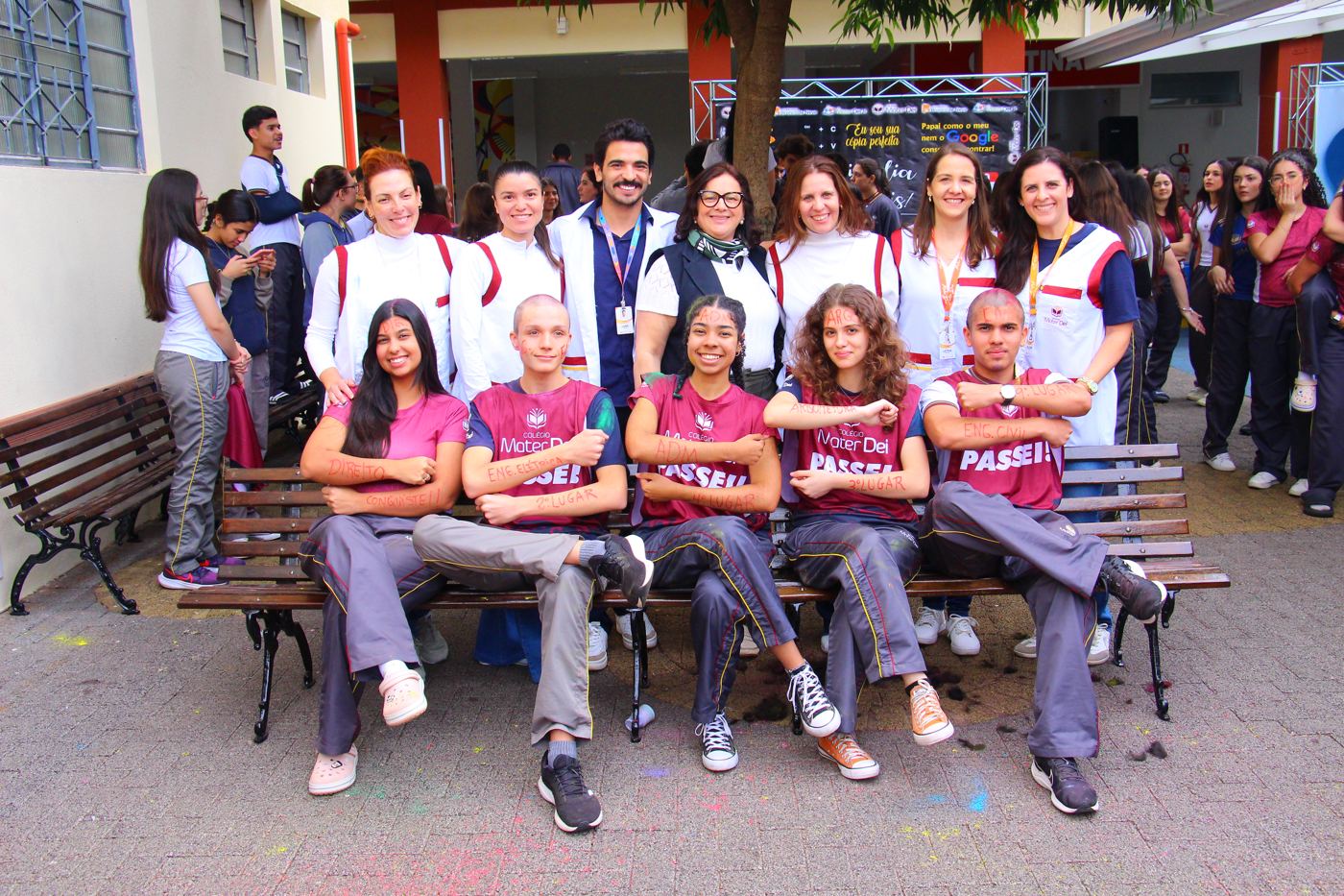 Alunos aprovados no vestibular comemorando com professores